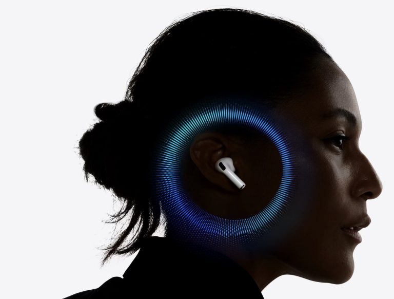 تظهر AirPods Pro داخل الأذن مع أمواج ضوئية زرقاء دائرية حول الرأس، وبروز سماعة بيضاء على خلفية بيضاء ناعمة بتباين واضح.