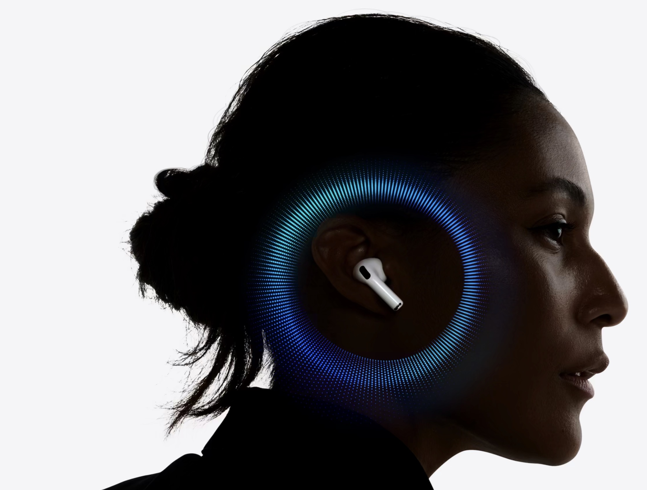 تظهر AirPods Pro داخل الأذن مع أمواج ضوئية زرقاء دائرية حول الرأس، وبروز سماعة بيضاء على خلفية بيضاء ناعمة بتباين واضح.