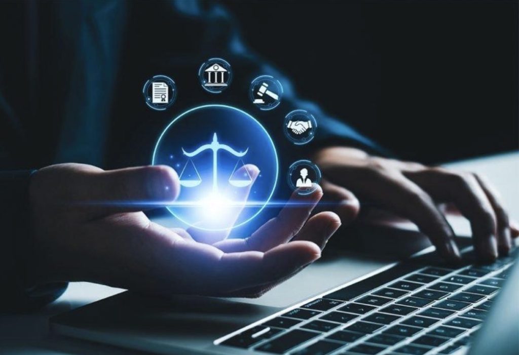 تجسيد إلغاء الدفع بالاختصاص المكاني وتوحيد النطاق القضائي داخل المملكة عبر منصات عدلية رقمية: يدّان تحملان رمز ميزان القانون فوق لوحة مفاتيح.